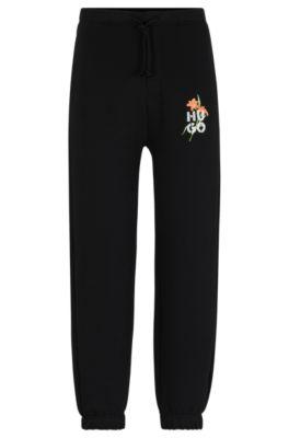 relaxed-fit tracksuit bottoms with floral logo artwork- black men's jogging pants