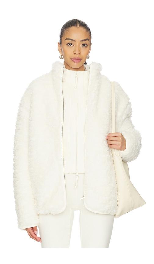 skims faux fur zip up mock neck jacket in cream.